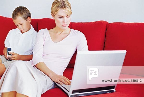 Mutter und Sohn mit Laptop und Handy