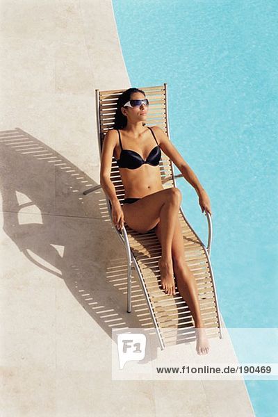 Frau beim Sonnenbaden am Pool