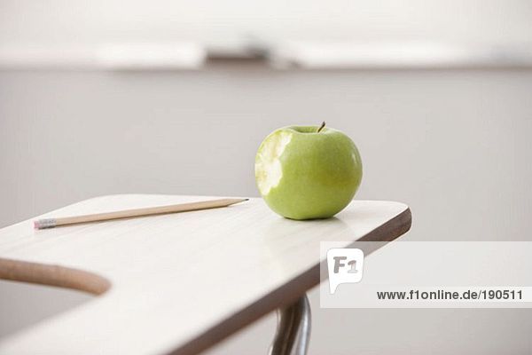 Apfel und Bleistift auf dem Schreibtisch