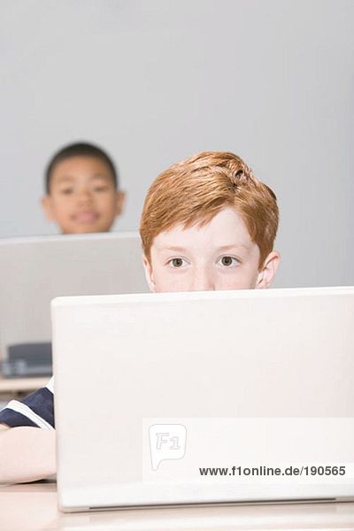 Jungen  die Laptops benutzen