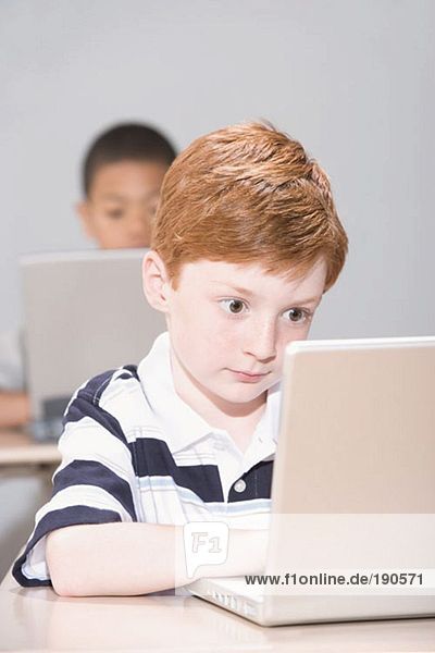 Boys using laptop computers