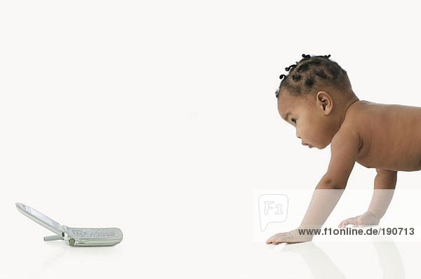 Baby krabbelt auf das Handy zu