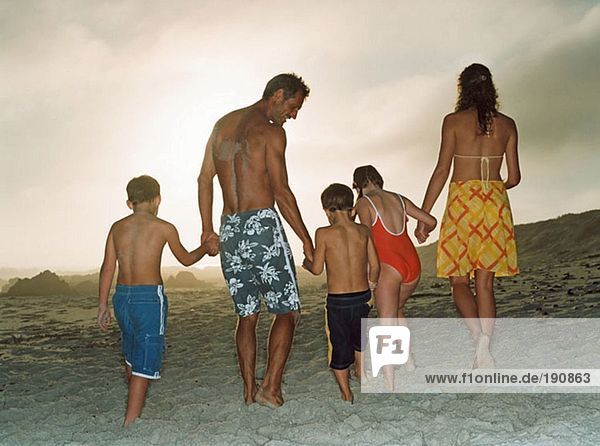 Family holding hands on the beach