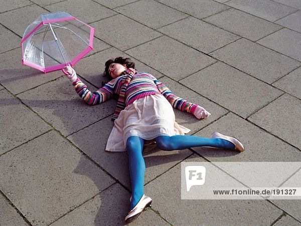 Frau mit Regenschirm liegend