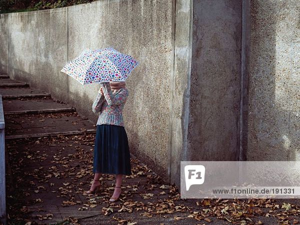 Frau mit fleckigem Regenschirm