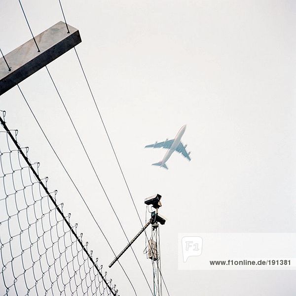 Flugzeug über Drahtzaun