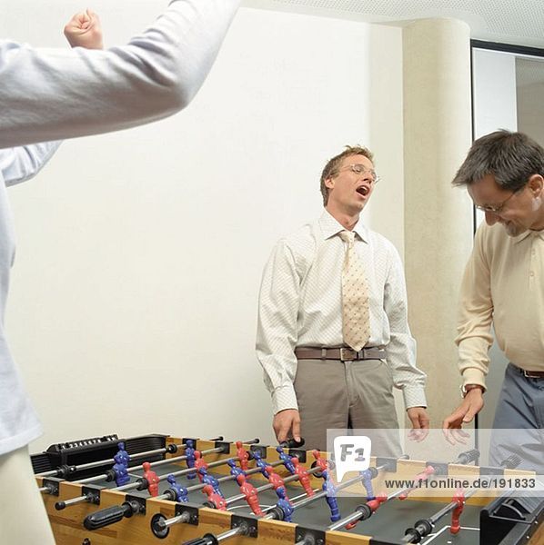 Businessmen playing table football