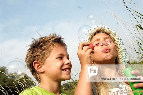 Boy und Girl blowing bubbles