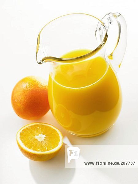 Orangensaft im Glaskrug  frische Orangen