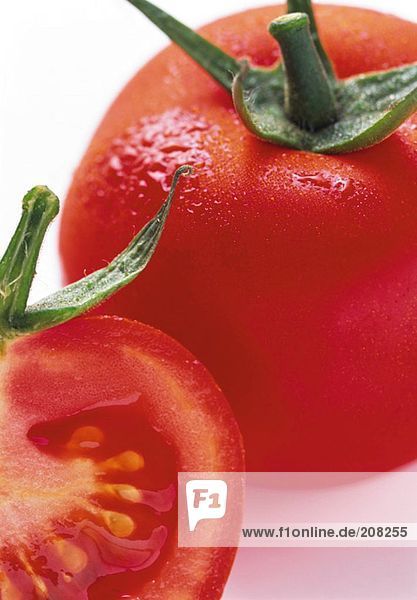Tomate  ganz und halbiert  mit Wassertropfen
