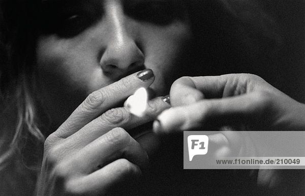 Frau beim Anzünden einer Zigarette