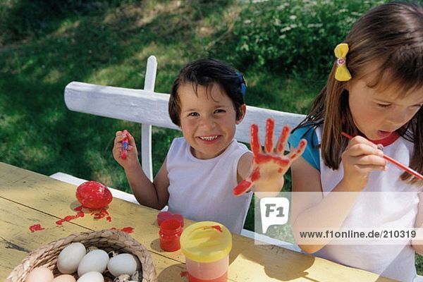 Mädchen malen Eier und Hände