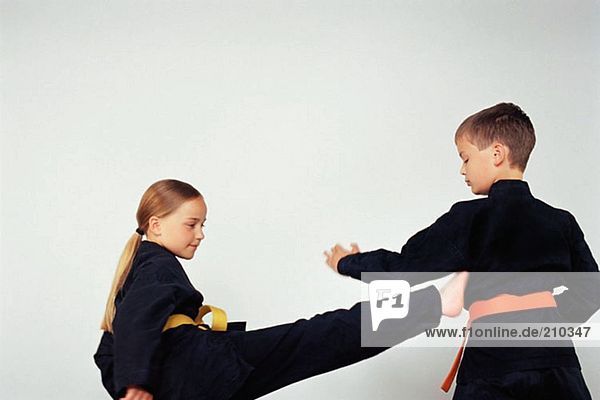 Mädchen und Junge beim Karate üben