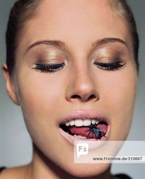 Frau mit Plastikfliege im Mund