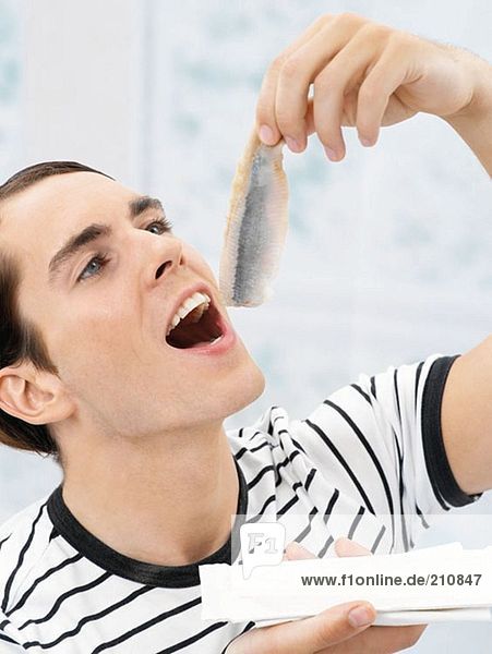 Mann isst rohen Fisch