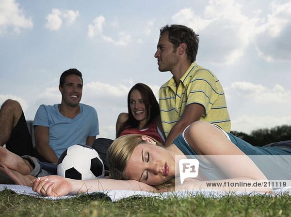 Junge Leute  die sich auf einem Feld ausruhen