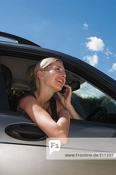 Woman in car using mobile phone