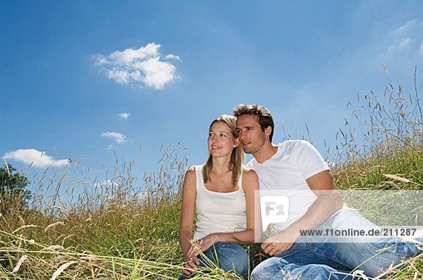 Paar auf einem Feld sitzend