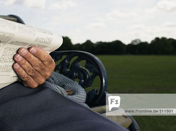 Älterer Mann beim Lesen im Park