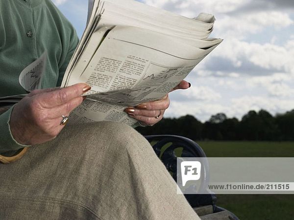 Ältere Frau beim Zeitungslesen