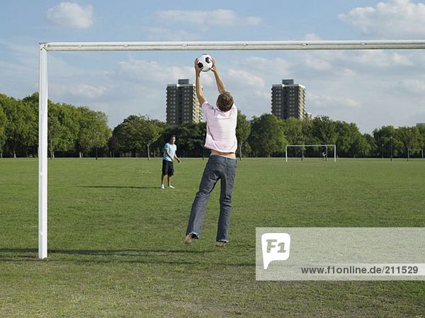 Männer spielen Fußball im Park