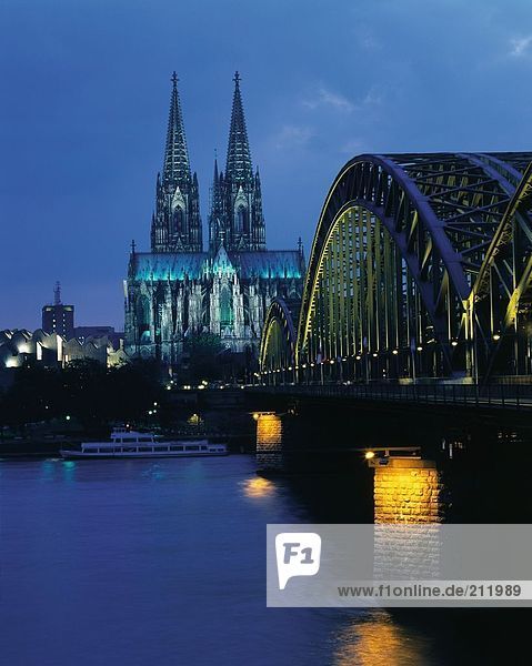Bridge across river lit up at dusk  River Rhine  Cologne  Germany