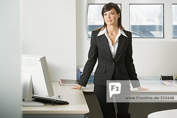 Geschäftsfrau auf dem Schreibtisch sitzend