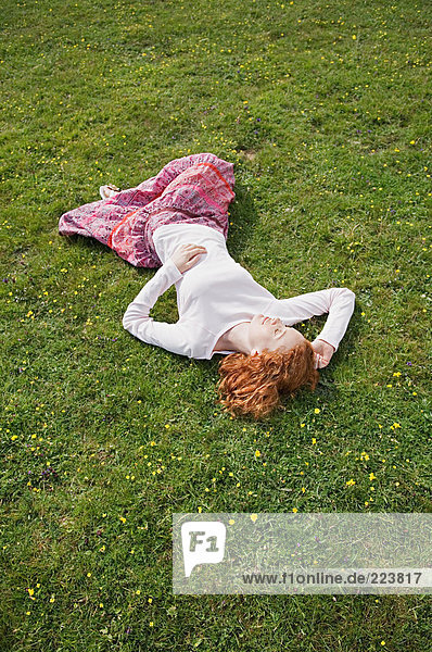 Frau schläft auf einem Feld