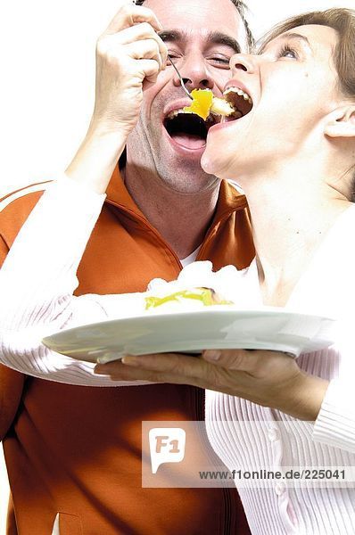 Close-up of couple eating cake