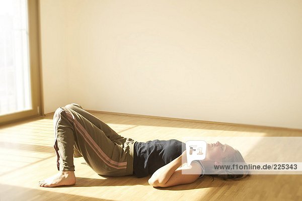 Young woman sleeping on wooden floor