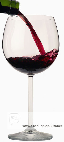 Rotwein wird in ein Rotweinglas gegossen