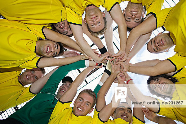 Fußballmannschaft beim Zusammenstellen der Hände