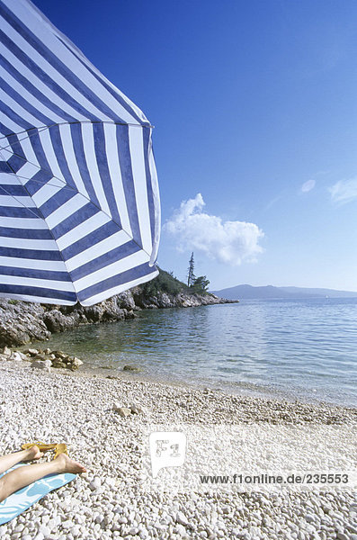 Kroatien  Dubrovnik  Frau auf Handtuch am Strand liegend  niedriger Abschnitt