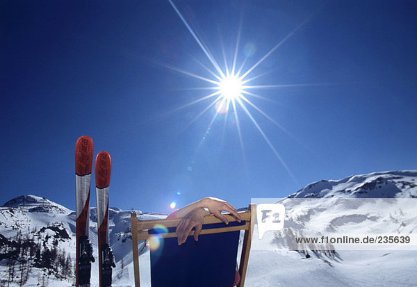 Person im Liegestuhl in den Alpen  Winter
