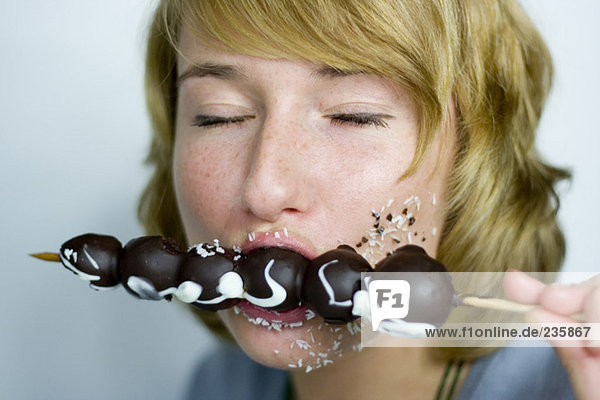 Woman eating chocolate fruit spit  closed eyes