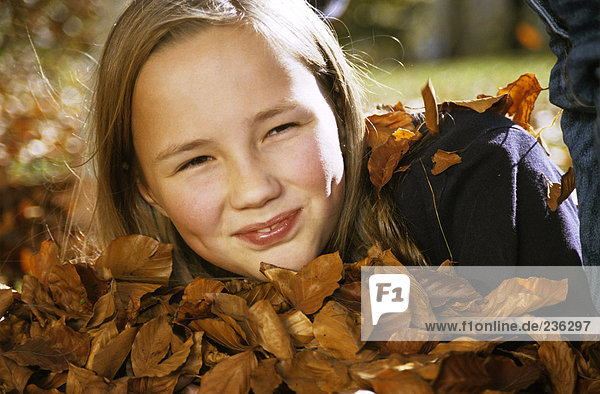 Girl (10-11) with autumn leaves  portrait