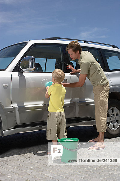 Vater und Sohn waschen das Auto