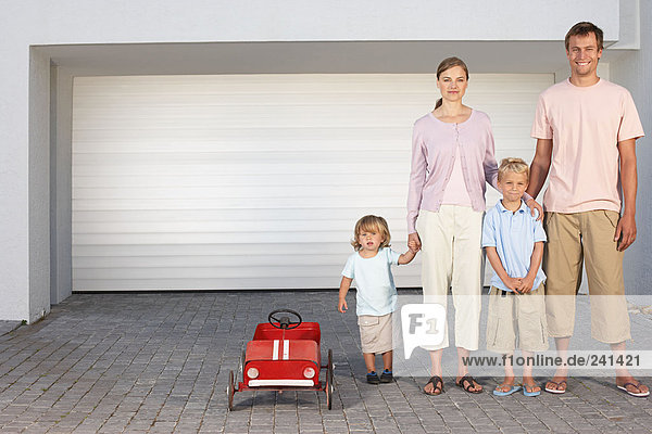 Familie stand in einer Reihe auf der Einfahrt mit Spielzeugauto