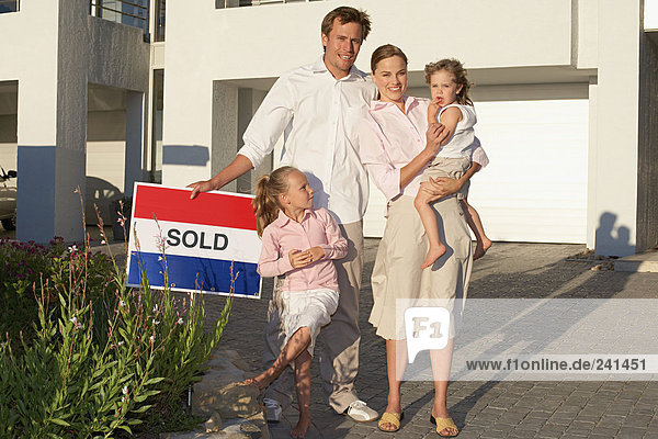 Familie stand vor dem Haus mit verkauftem Schild