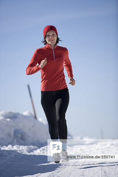 Young woman jogging in snow