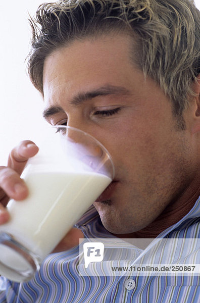 Young man drinking glass of milk  close-up