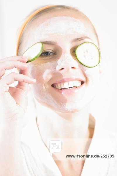 Junge Frau mit facial Mask und Gurken Scheiben auf ihre Augen Nahaufnahme