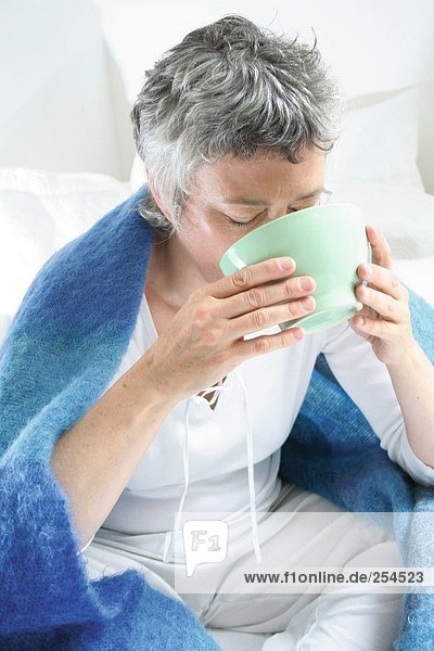 Senior woman inhaling steam for a cold