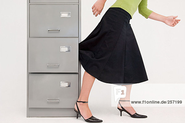 Businesswoman with skirt trapped in drawer