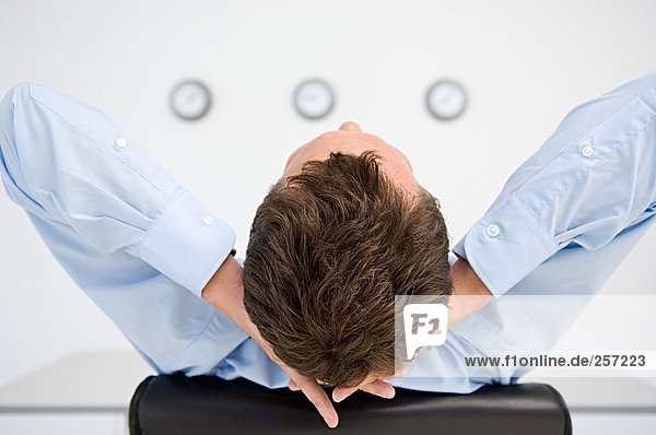 Businessman with relaxing with hands behind head