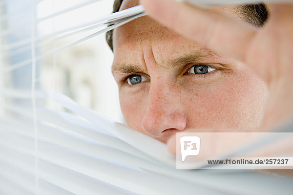 Businessman looking through blinds