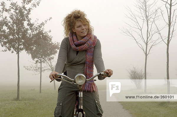 Frau auf dem Fahrrad im Herbst