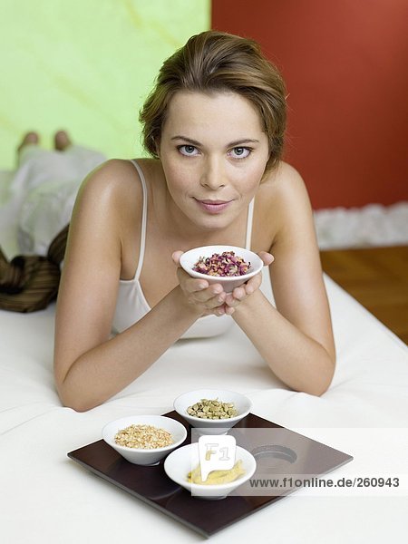 Woman lying on bed with spice in bowls