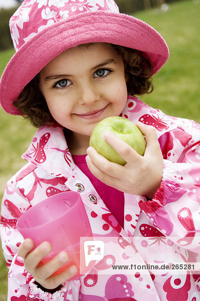 Kleines Mädchen mit Apfel und Glas