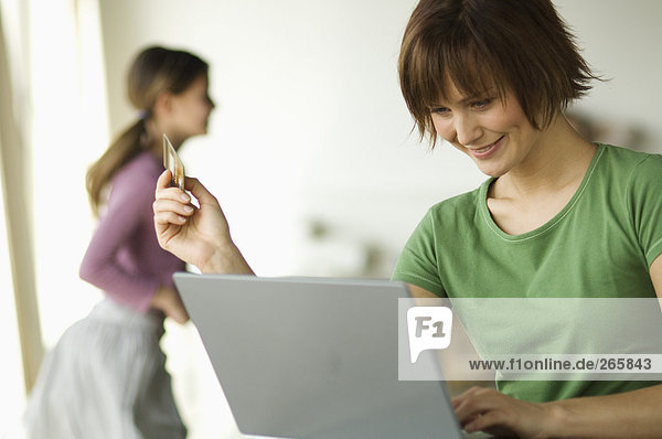 Frau mit Computer  Mädchen im Hintergrund